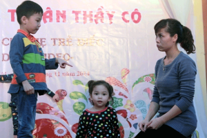 Khôi Nguyên cùng mẹ Phương Hà và em gái kể chuyện bằng ngôn ngữ ký hiệu tại một sự kiện của cộng đồng Điếc tổ chức tại Hà Nội. Ảnh: IDEO